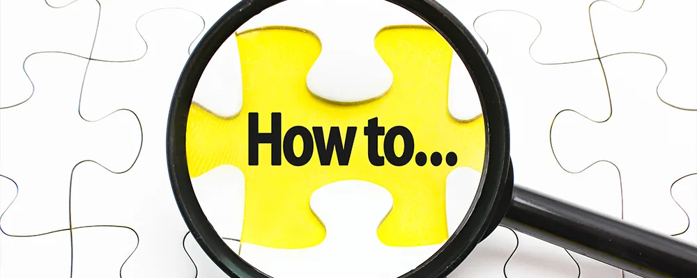 虫眼鏡の中に「HOW to…」という文字が見える画像。