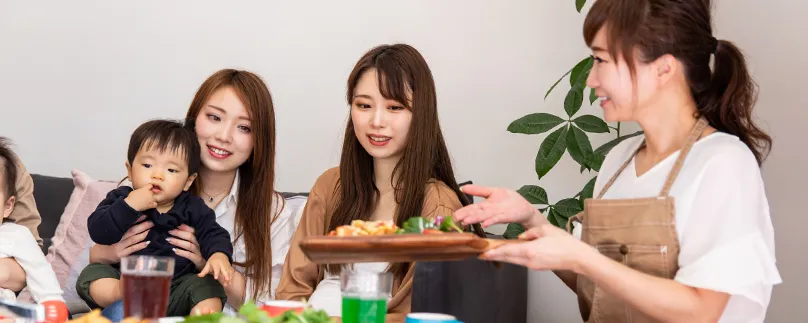 店員が家族連れのお客様に料理を運んでいる様子