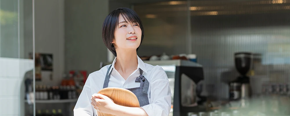 上を見上げる女性店員の画像