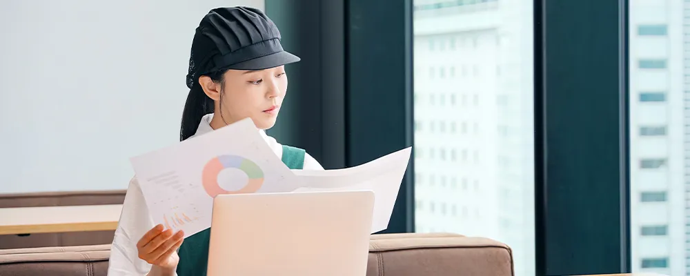 資料を確認しながらパソコン作業をする店舗スタッフの画像