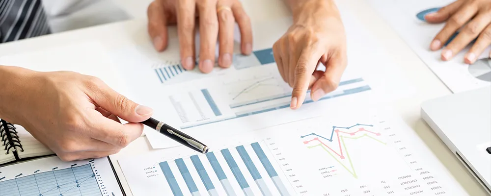資料のグラフを指差すビジネスパーソンの手元の画像