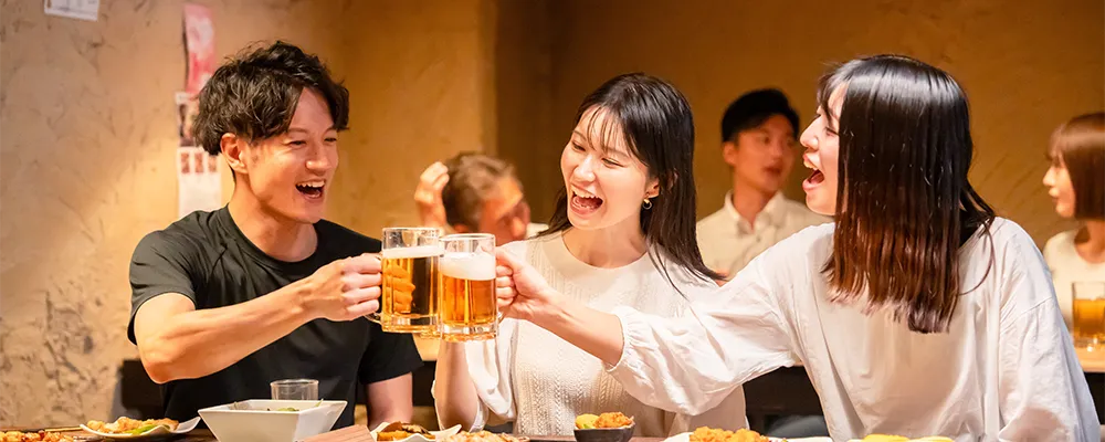 居酒屋で男女3人が乾杯をしている画像