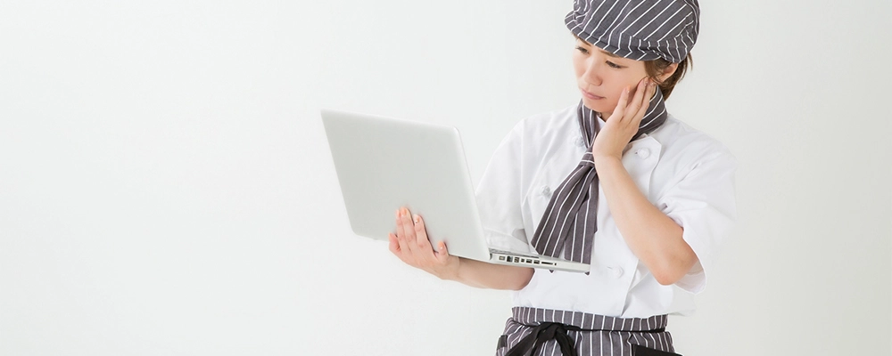 パソコンを持った従業員が悩んでいる様子